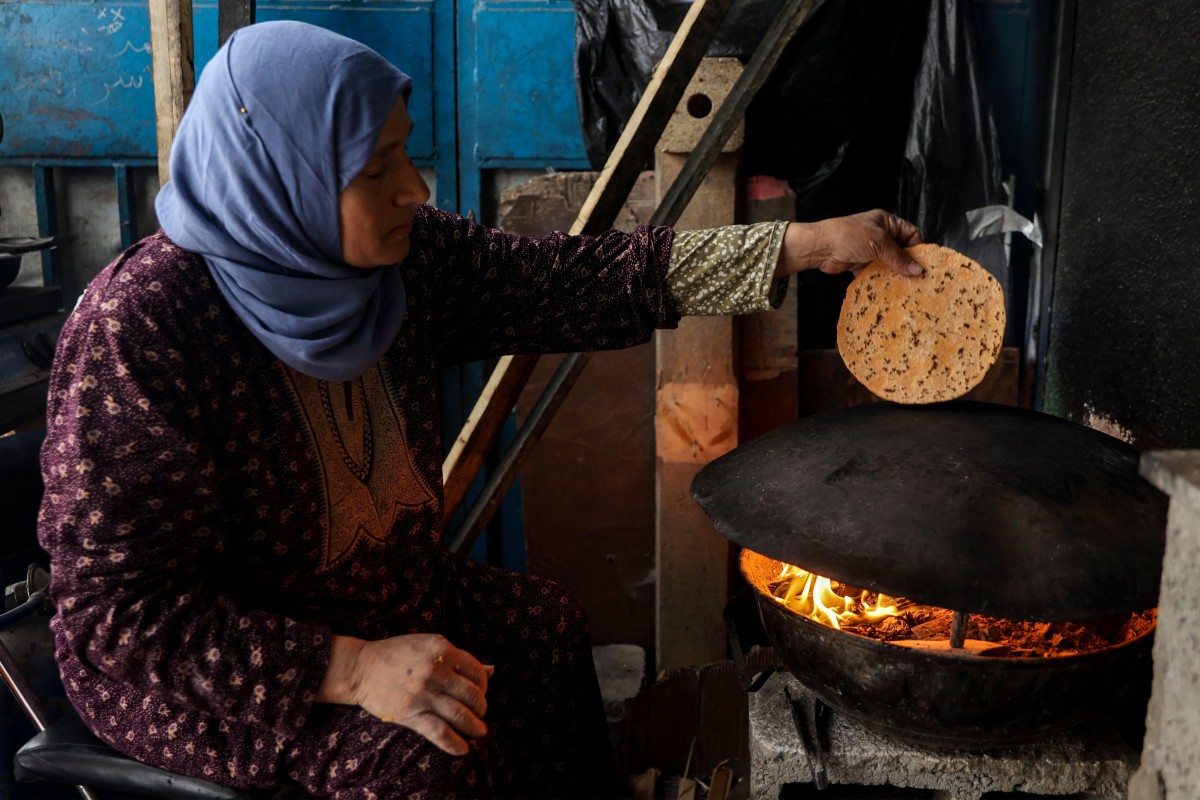 سيدة فلسطينية تخبز خبزاً من العدس المطحون بسبب نقص الطحين في ‏مخيم جباليا (أ ف ب)‏