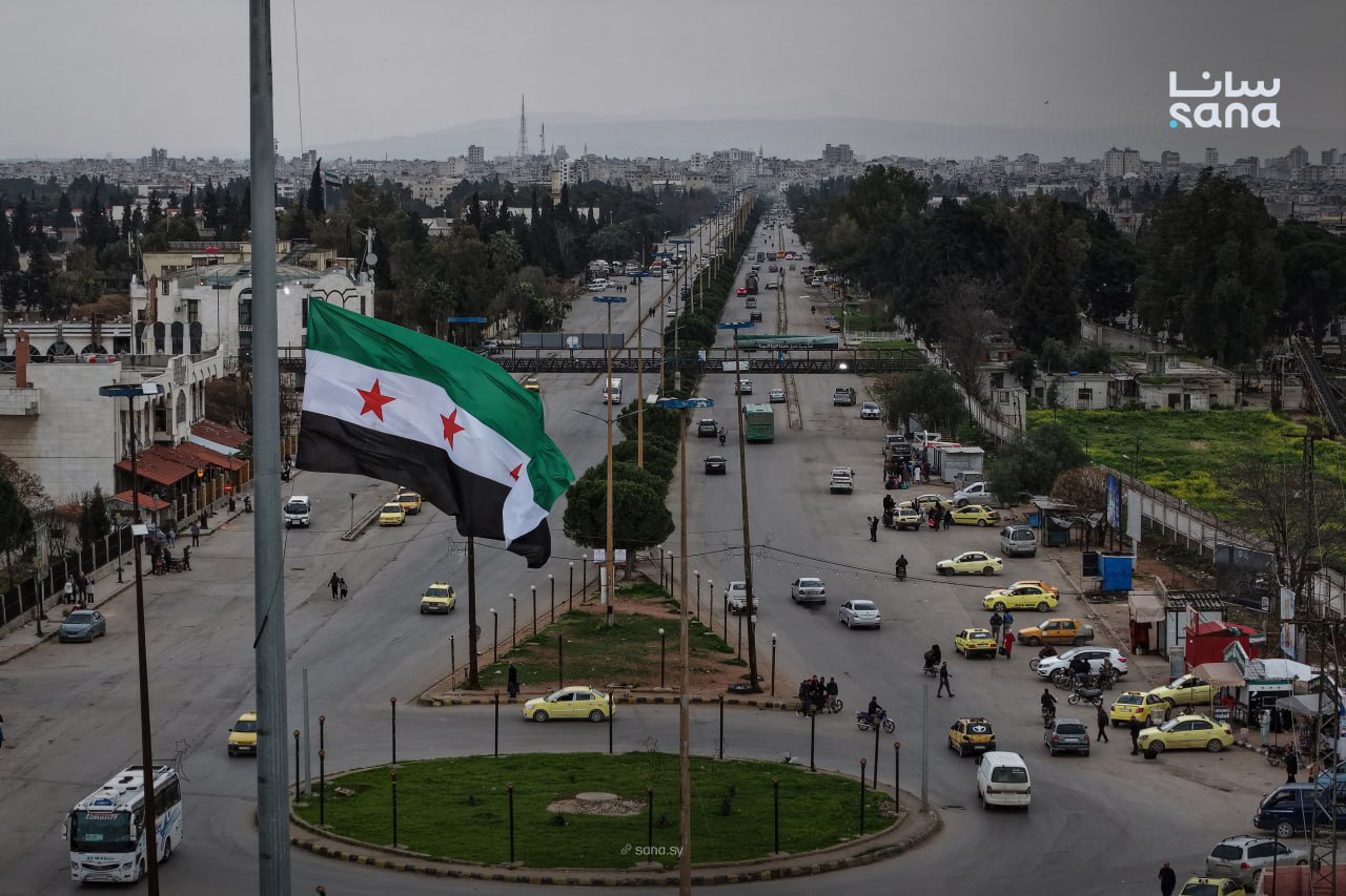  العلم السوري في ساحة حمص (سانا)