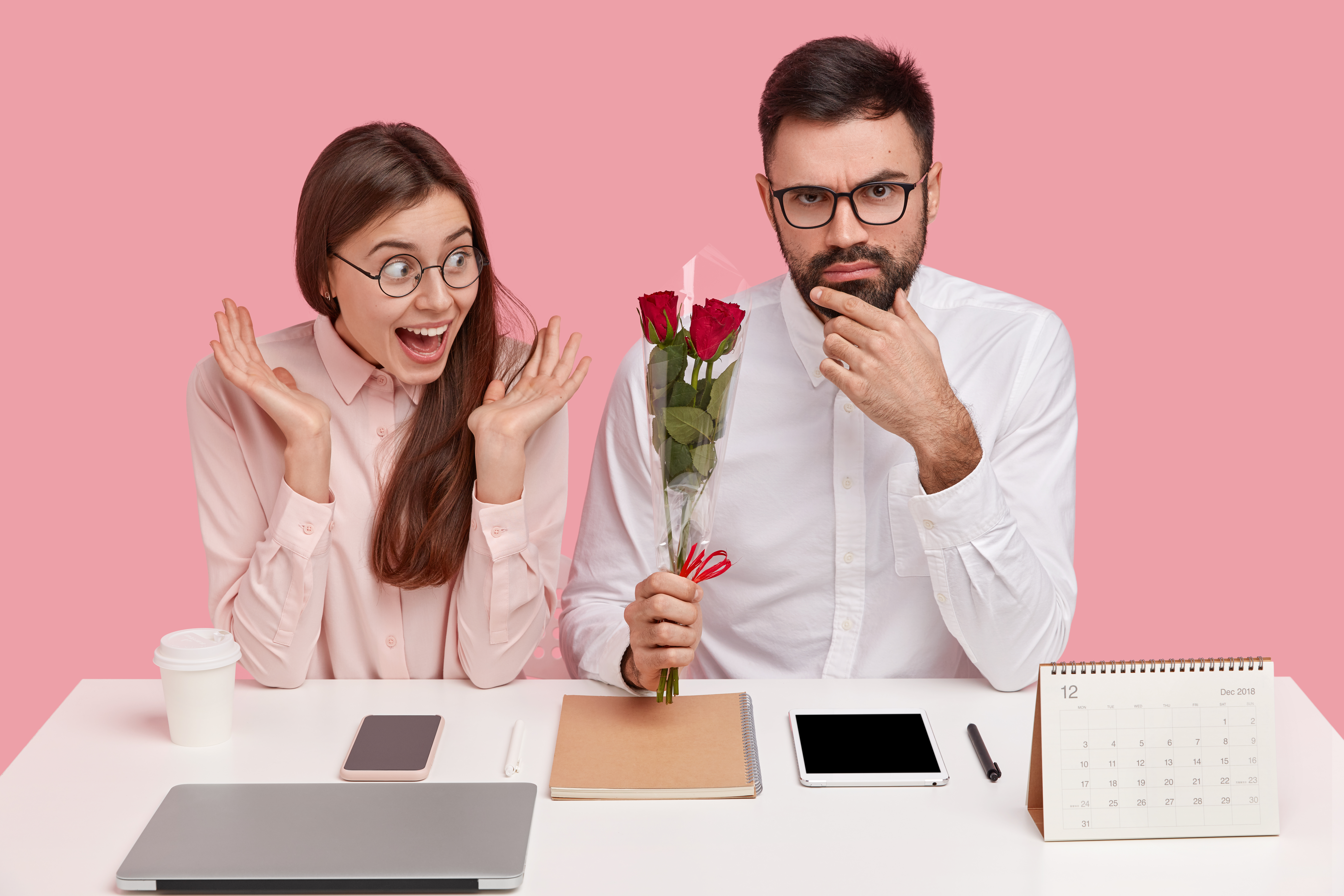 موظفة تتلقى باقة زهور من زميلها داخل المكتب، في مشهد يرمز إلى علاقة عاطفية في بيئة العمل. (magnific - تعبيرية)