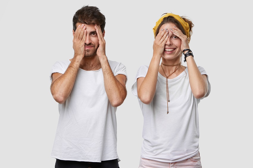 امرأة ورجل يخفيان مشاعرهما بالإبتسامة (Freepik)