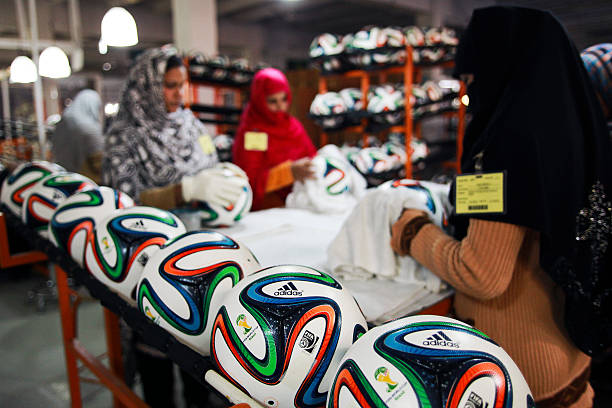 عاملات في باكستان يخيطن كرات كأس العالم (غيتي)