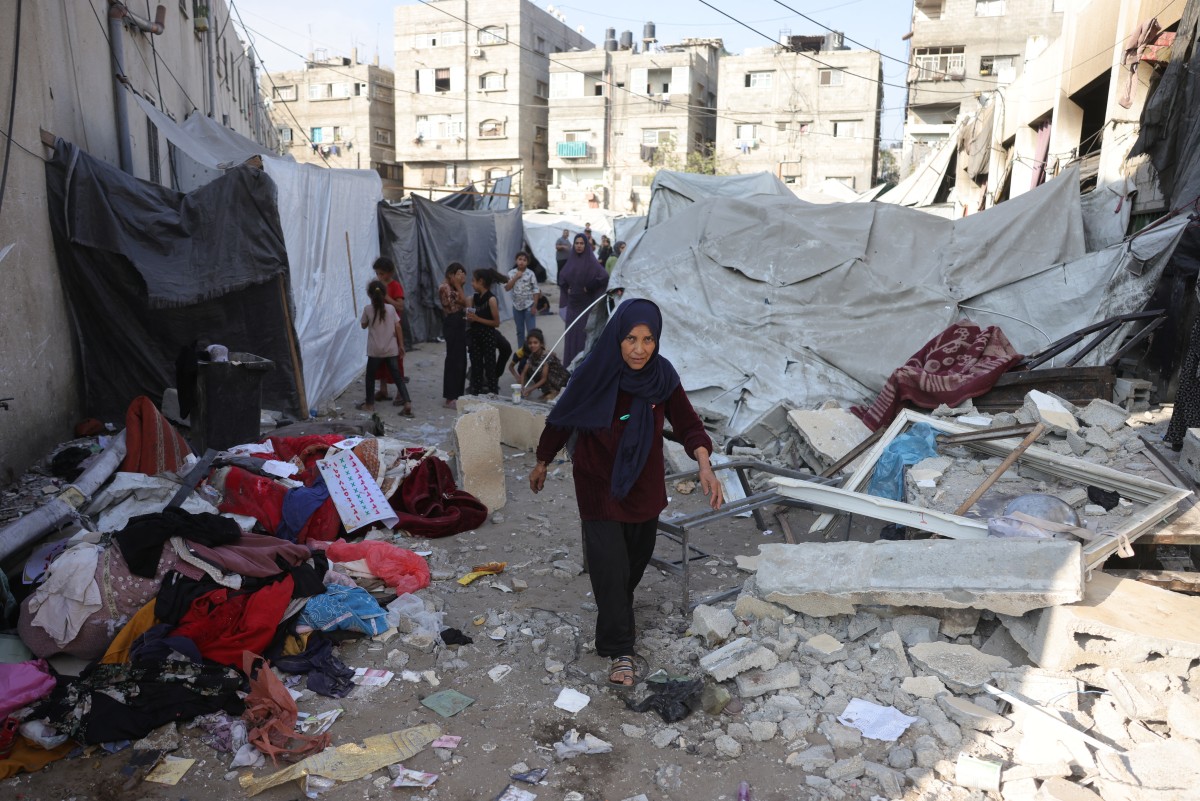 فلسطينيون يتفقدون الأضرار في مدرسة حليمة السعدية في جباليا. (أ ف ب) 