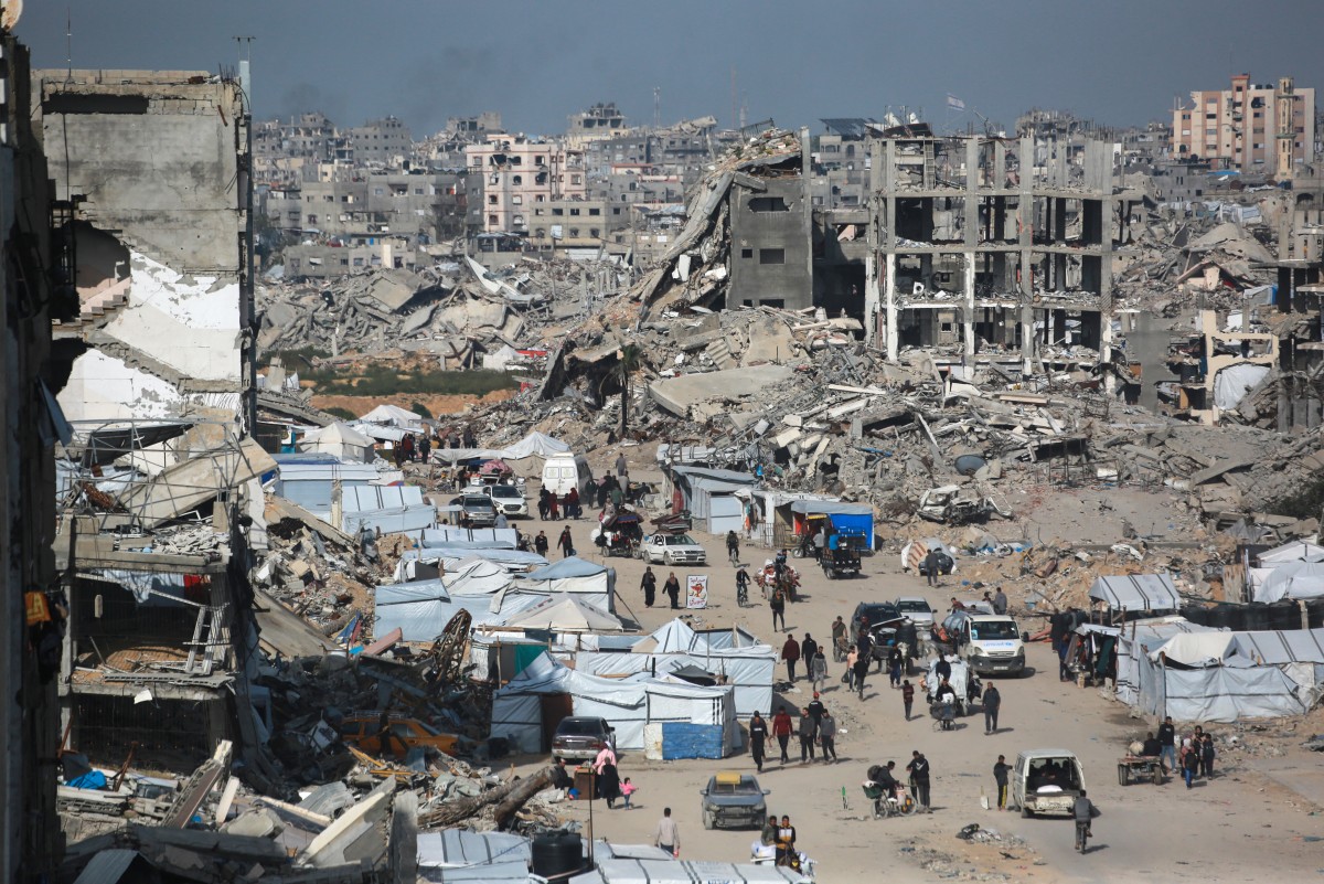 فلسطينيون هاربون من القصف الإسرائيلي يقودون مركبات تحمل أمتعتهم على محور رئيسي في بيت لاهيا. (أ ف ب)