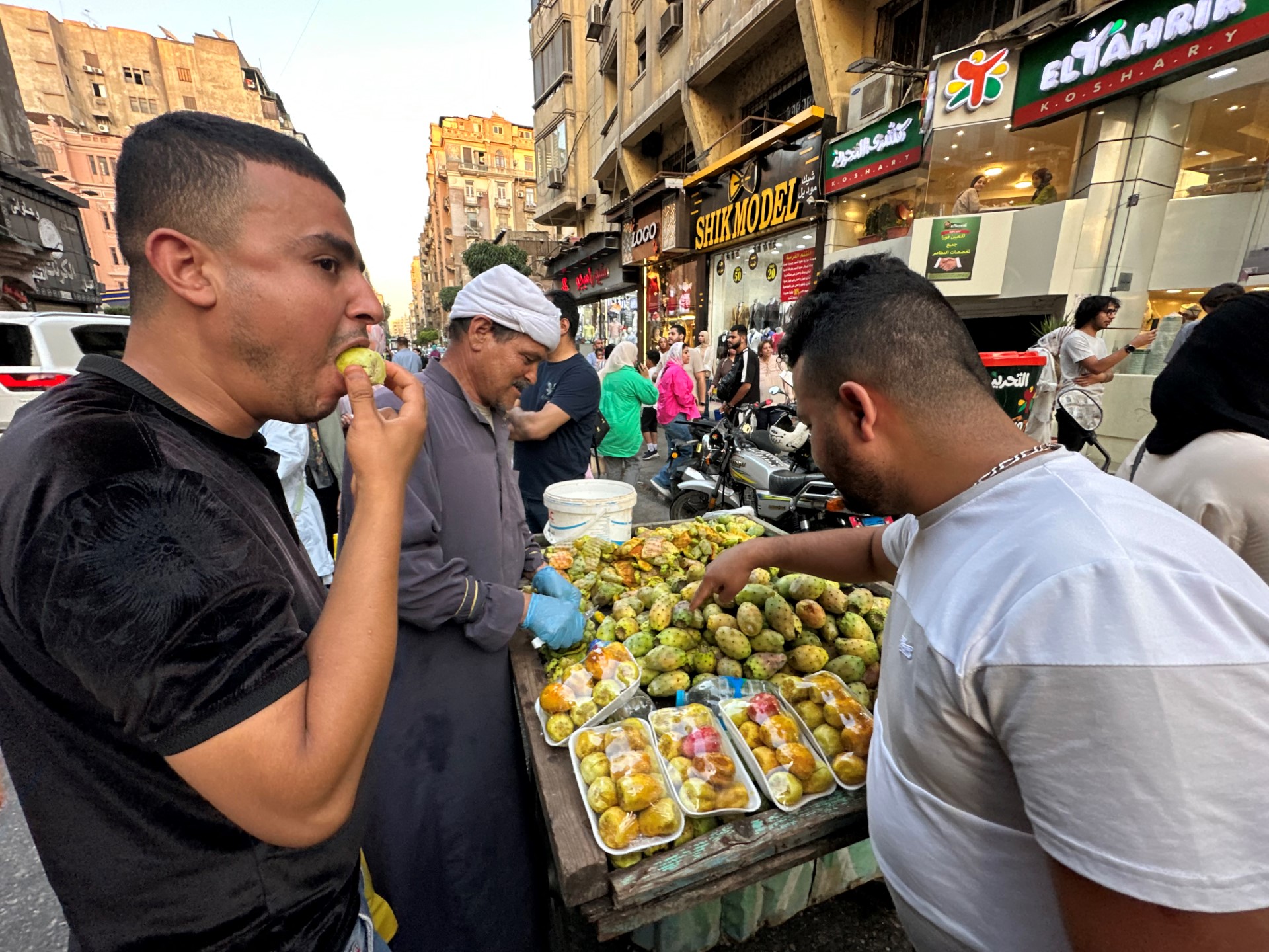 شاب مصري يتناول تين شوكي من على عربة في الشارع (أ ف ب)