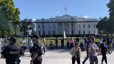 عناصر من الشرطة وقفوا قرب سيّاح خارج البيت الأبيض في واشنطن (أ ف ب).