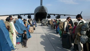 أفغان يصطفون لركوب طائرة عسكرية أميركية في مطار كابول (أ ف ب).