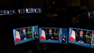 صور مباشرة للرئيس الفرنسي إيمانويل ماكرون على شاشات الكمبيوتر أثناء قيامه بإلقاء خطابه المتلفز بمناسبة رأس السنة الجديدة إلى الأمة من قصر الإليزيه (أ ف ب).