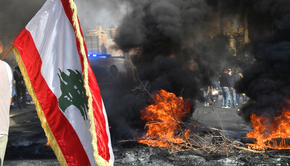 العلم اللبناني وسط اشتعال الشارع (حسن عسل).