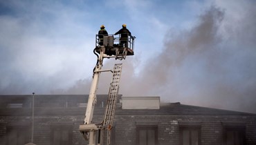 رجال إطفاء خلال محاولتهم اطفاء حريق مندلع في مبنى الجمعية الوطنية في كيب تاون (2 ك2 2022، أ ف ب). 