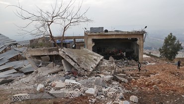 اشخاص يتفقدون أضرارا لحقت بمحطة مياه الأرشاني في قرية الأرشاني شمال شرق إدلب بعد غارة جوية عليها (2 ك2 2022، أ ف ب). 