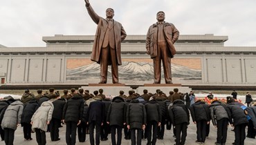 اشخاص انحنوا امام تمثالي الرئيسين كيم إيل سونغ وكيم جونغ إيل في مانسو هيل في بيونغ يانغ، بمناسبة يوم رأس السنة الجديدة (1 ك2 2022، ا ف ب). 