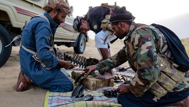 مقاتلون يمنيون موالون للحكومة يشحنون أسلحتهم بالذخيرة خلال قتالهم مع الحوثيين في جنوب محافظة مأرب (5 ك2 2022/ أ ف ب). 