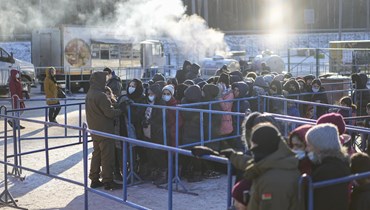 مهاجرون اصطفوا لتلقي الطعام في مركز الخدمات اللوجستية عند نقطة التفتيش بروزجي على الحدود بين بيلاروسيا وبولندا بالقرب من غرودنو في بيلاروسيا (أ ب). 