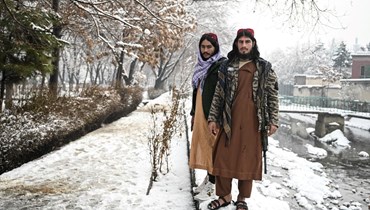 مقاتلان من طالبان وقفا في حديقة بعد تساقط الثلوج بغزارة في كابول (5 ك2 2022، أ ف ب). 