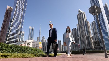 موظفان يتوجهان إلى العمل في أول يوم جمعة عمل في إمارة دبي (78 ك2 2022، ا ف ب). 