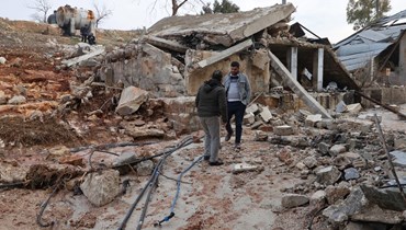 أشخاص يتفقدون أضرارا لحقت بمحطة مياه الأرشاني في قرية الارشاني شمال مدينة إدلب، من جراء غارة جوية روسية عليها (2 ك2 2022، أ ف ب). 