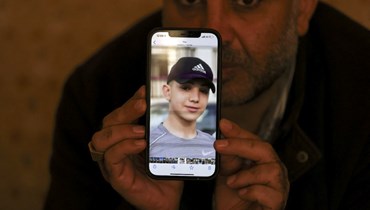 معمر نخلة، والد الأسير الفلسطيني أمل، يعرض صورة ابنه على هاتفه، في مخيم الجلزون للاجئين قرب رام الله بالضفة (8 ك2 2022، ا ف ب). 
