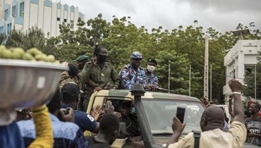 اشخاص يهتفون بينما تمر قوات الأمن في شوارع باماكو بعد يوم على احتجاز الرئيس كيتا (19 آب 2020، أ ب). 