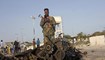 جندي وقف عند حطام مركبة في موقع هجوم انتحاري بسيارة مفخخة على قافلة في مقديشو بالصومال (11 ت2 2021، ا ب). 