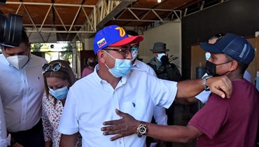 غاريدو يحيي أحد مؤيديه بعد التصويت في باريناس بفنزويلا (9 ك2 2022، أ ف ب). 