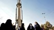 إيرانيات وقفن قرب صاروخ غيام معروض في طهران (7 ك2 2022، أ ف ب). 