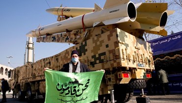 إيراني وقف قرب صواريخ معروضة في طهران (7 ك2 2022، ا ف ب).
