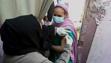 امرأة تتلقى لقاح كورونا في كراتشي (11 ك2 2022، أ ف ب). 