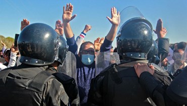عناصر من قوات الأمن يواجهون متظاهرين تونسيين مناهضين للحكومة خلال إضراب عام في 10 تشرين الثاني 2021، بعد إعادة فتح مكب نفايات في بلدة عقارب التونسية بوسط صفاقس (أ ف ب). 