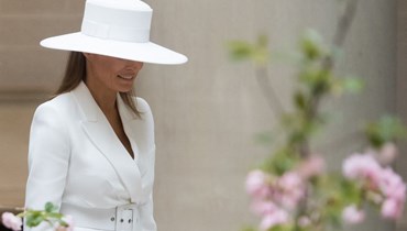 ميلانيا ترامب ترتدي القبعة البيضاء المعروضة للبيع عام 2018 خلال استقبال ماكرون وزوجته (أ ف ب).