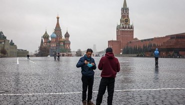 رجلان يقفان في الساحة الحمراء المقفرة موسكو (أ ف ب).