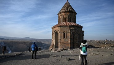 سياح يلتقطون الصور قرب كنيسة القديس غريغوريوس في مدينة آني القديمة في قارص (7 ك2 2022، أ ف ب). 