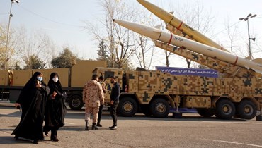 نساء إيرانيات يمرن قرب صاروخي "ذو الفقار بصير" و"دزفول" المعروضين في طهران (7 ك2 2022، أ ف ب). 