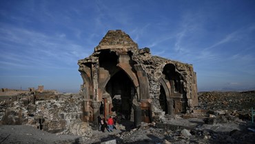 سياح يمشون في مدينة العاني القديمة في قارص قرب الحدود التركية الأرمينية (7 ك2 2022، أ ف ب). 