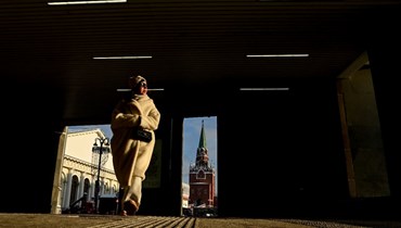 امرأة تمشي، وبدا خلفها أحد ابراج الكرملين في وسط موسكو (12 ك2 2022، أ ف ب). 