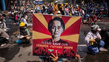 متظاهر يحمل صورة لأونغ سان سو تشي خلال تظاهرة في يانغون ضد الانقلاب العسكري (2 آذار 2021، ا ف ب). 
