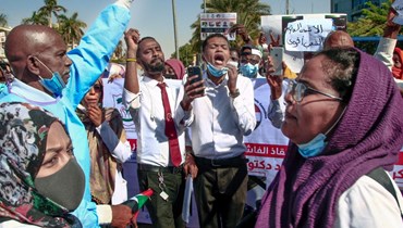 أطباء سودانيون يتظاهرون في الخرطوم للتنديد بهجمات قوات الأمن على الكوادر الطبية خلال المسيرات الاحتجاجية (16 ك2 2022، ا ف ب). 