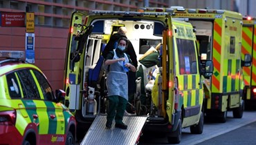 مسعفون يعملون داخل سيارة إسعاف متوقفة خارج مستشفى لندن الملكي في شرق لندن (7 ك2 2022، أ ف ب). 