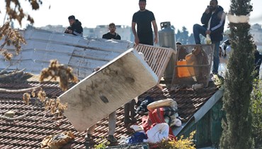 رجال فلسطينيون تحصنوا على سطح منزل بينما تستعد الشرطة الإسرائيلية لإخلاء المبنى في حي الشيخ جراح شرق القدس (17 ك2 2022، أ ف ب).