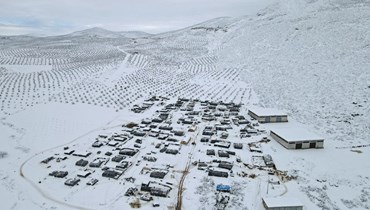 صورة جوية لمخيم للنازحين مغطى بالثلوج في بلدة راجو بالريف الشمالي لحلب (19 ك2 2022، ا ف ب). 