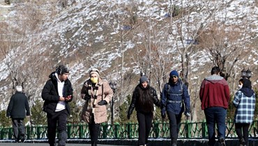 إيرانيون يزورون قمة توشال عند سلسلة جبال البرز شمال طهران (18 ك2 2022، أ ف ب). 