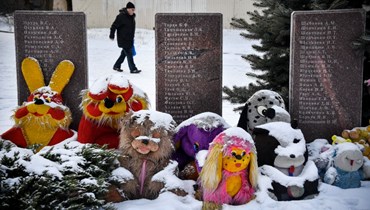 رجل يمر قرب نصب تذكاري لضحايا المعارك اقيم في قرية فيزيولوي في ضواحي دونيتسك شرق أوكرانيا (18 ك2 2022، أ ف ب).