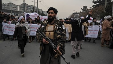 مقاتل من طالبان وقف خلال تظاهرة منددة بالاحتجاج الأخير الذي نظمته ناشطات حقوق المرأة الأفغانية، في كابول (21 ك2 2022، أ ف ب). 