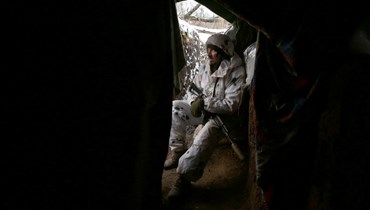 جندي أوكراني يجلس في خندق على خط المواجهة مع الانفصاليين بالقرب من قرية فيركنيتوريتسك في منطقة دونيتسك (18 ك2 2022، أ ف ب). 