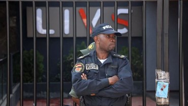 شرطي وقف عند مدخل ملهى "ليفس" الليلي حيث اندلع الحريق في منطقة باستوس في ياوندي (23 ك2 2022، ا ف ب). 