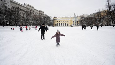 أشخاص يتزلجون على بركة متجمدة في وسط موسكو (23 ك2 2022، أ ف ب). 