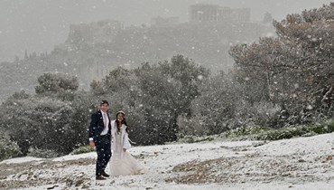 عروسان من الولايات المتحدة يمشيان قرب الأكروبوليس في أثينا (24 ك2 2022، ا ف ب). 