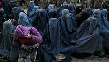 نساء ينتظرن خبزا مجانيا أمام مخبز في كابول (24 ك2 2022، ا ف ب). 