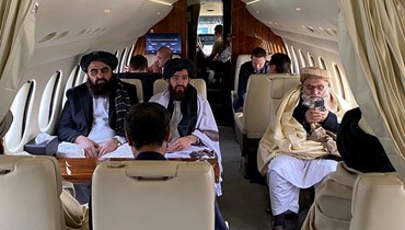 وزير الخارجية الأفغاني أمير خان متقي (إلى اليسار) واعضاء آخرون في وفد طالبان، على متن طائرة في مطار كابول قبل توجههم إلى أوسلو (22 ك2 2022، أ ف ب).