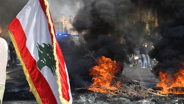 العلم اللبناني وسط اشتعال الشارع (حسن عسل).