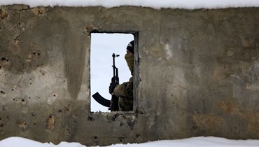مقاتل سوري خلال تدريب عسكري في قاعدة مغطاة بالثلوج في منطقة عفرين بالريف الشمالي الغربي لمحافظة حلب (26 ك2 2022، أ ف ب). 